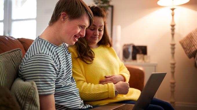 Two people looking at a laptop screen