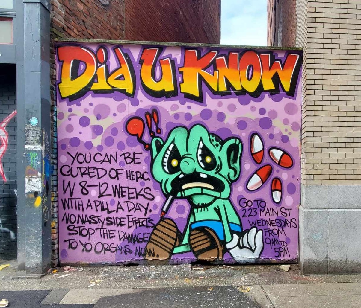 Graffiti text: You can be cured of Hep C Green cartoon character with red and white pills