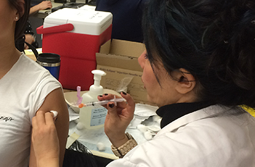 Nurse gives injection to teenager